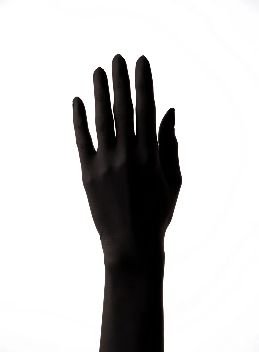 Hand in a matte black glove — tennis bracelet on the wrist, to scale